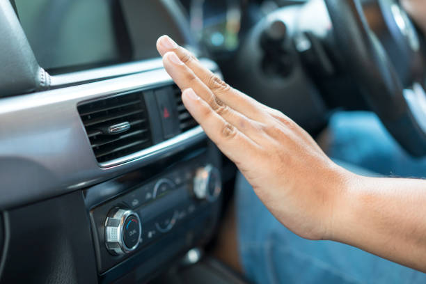 Main qui teste la clim d'une voiture