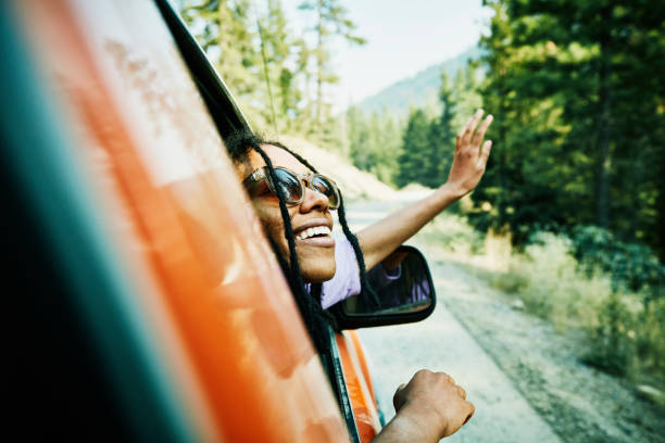 Femme qui sort sa tête par la fenêtre d'une voiture